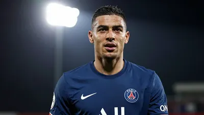 A 30-year-old Paris FC midfielder, with a muscular build, wearing a solid blue jersey, photographed with an 85mm f/1.4 lens