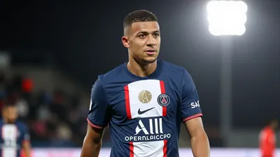 A photorealistic image of an anonymous young striker with a determined expression, wearing a Paris FC jersey in navy blue...
