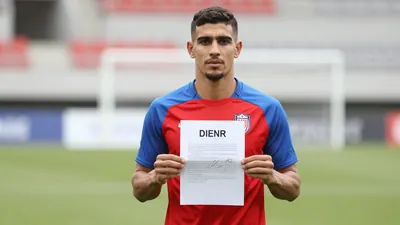 Mid-30s athletic forward, muscular torso, short dark hair, intense eyes, holding a signed contract in both hands...