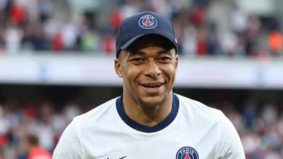 A head-and-shoulders photo of an Italian player with a Paris FC jersey, wearing a Paris FC hat, with a blurred background...